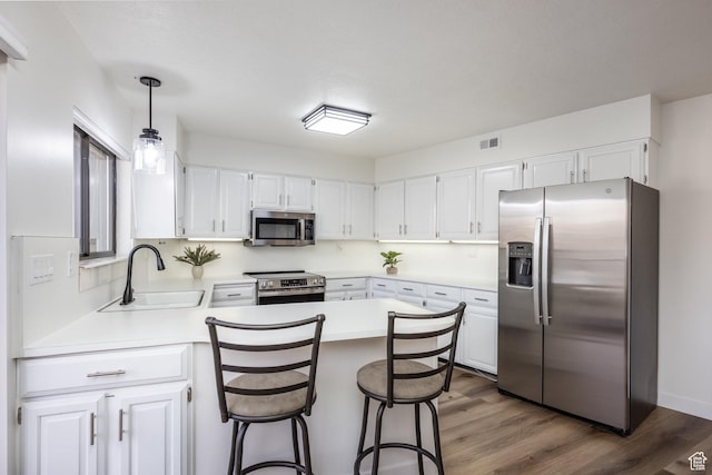 245 N Vine St W Unit 501, Salt Lake City, UT 84103 - kitchen featuring sink, dark wood-type flooring, appliances with stainless steel finishes, white cabinets, and decorative light fixtures