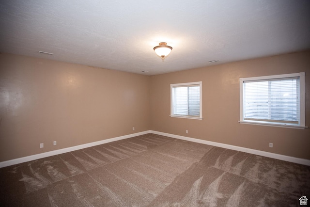 carpeted empty room with visible vents and baseboards
