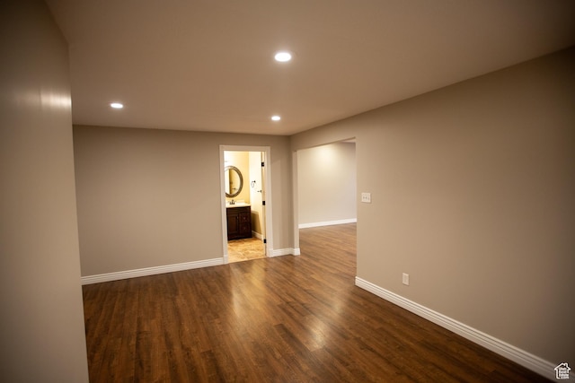 empty room featuring recessed lighting, wood finished floors, and baseboards