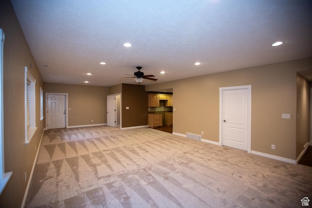 unfurnished living room with recessed lighting, baseboards, visible vents, and light colored carpet