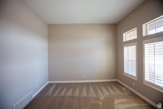 unfurnished room featuring carpet floors, visible vents, and baseboards