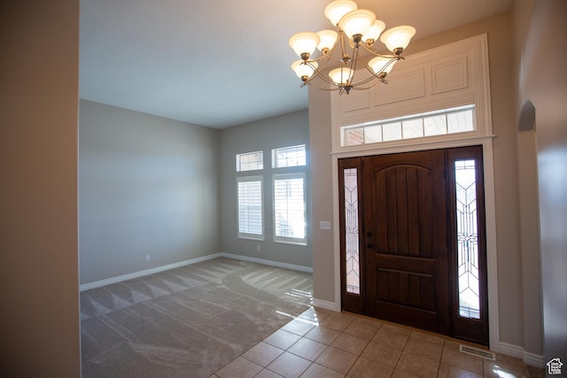 foyer with visible vents, baseboards, tile patterned floors, carpet flooring, and a notable chandelier