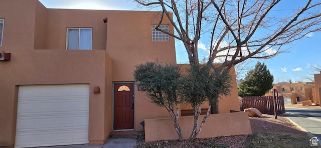 pueblo revival-style home featuring a garage
