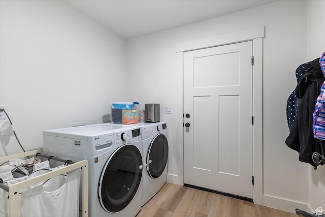 clothes washing area with light hardwood / wood-style floors and independent washer and dryer