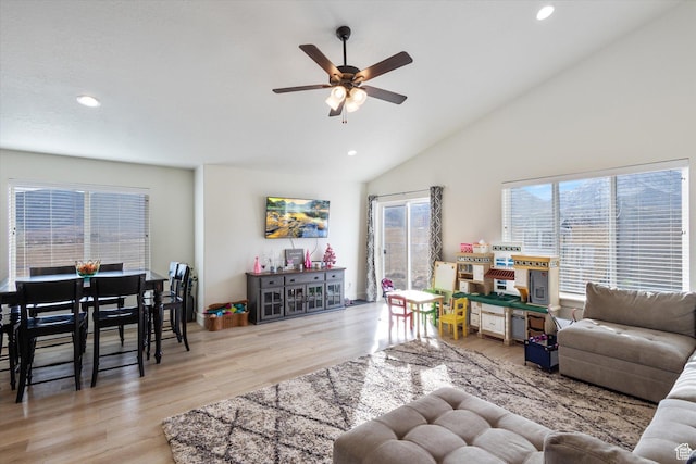 living room featuring high vaulted ceiling, ceiling fan, and light hardwood / wood-style flooring