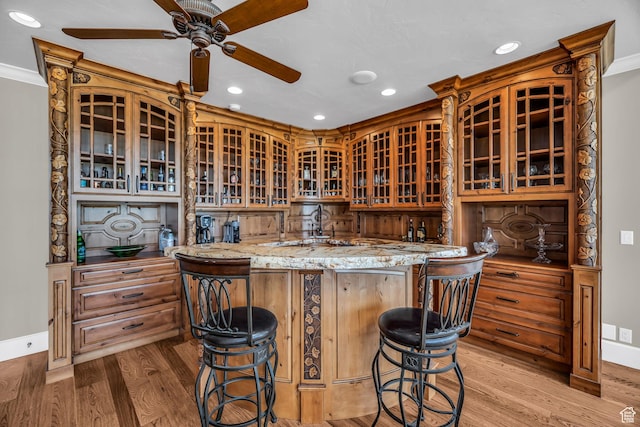 2410 E Center Creek Rd, Heber City, UT 84032 - kitchen with a breakfast bar, light hardwood / wood-style floors, kitchen peninsula, crown molding, and light stone countertops