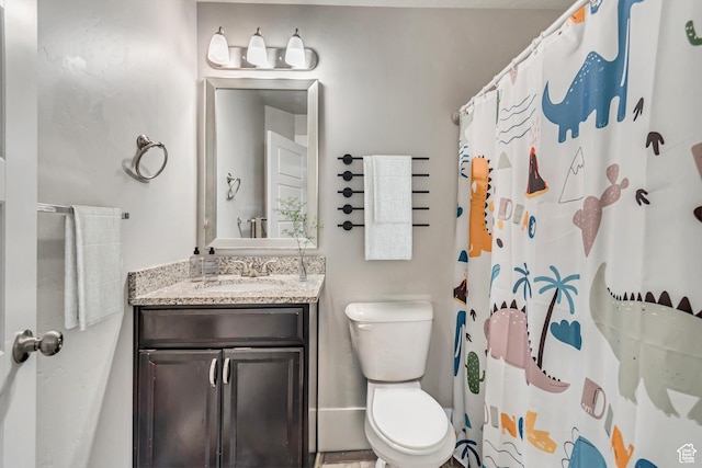 bathroom featuring walk in shower, vanity, and toilet