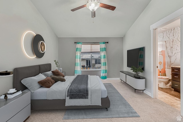 bedroom with ceiling fan, light colored carpet, lofted ceiling, and connected bathroom