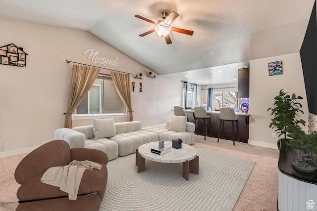carpeted living room with ceiling fan and lofted ceiling