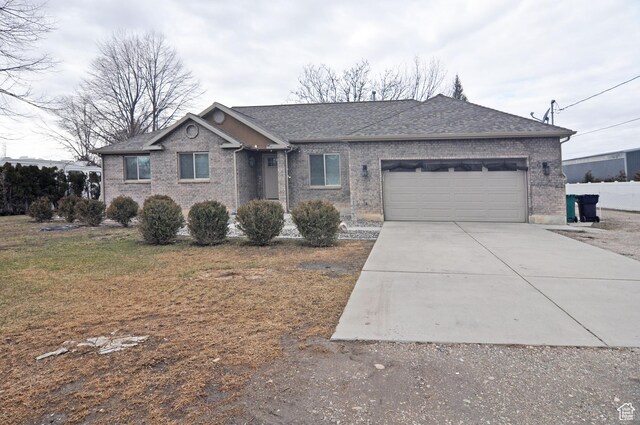 ranch-style home with a garage and a front lawn