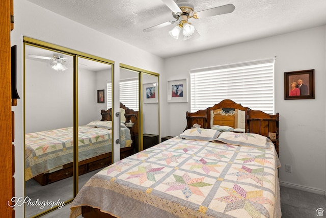 bedroom featuring ceiling fan, carpet floors, a textured ceiling, and two closets