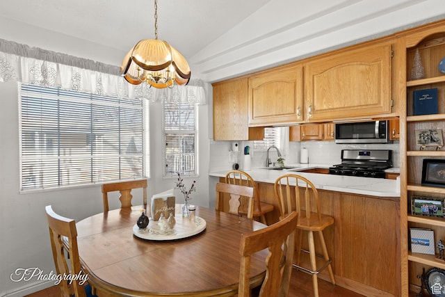 dining area featuring lofted ceiling, sink, and an inviting chandelier