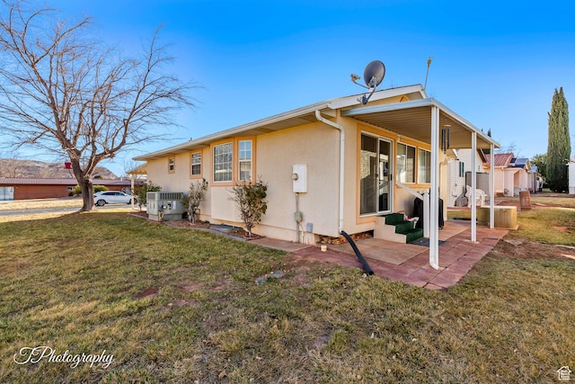 back of property with a yard, a patio area, and central air condition unit