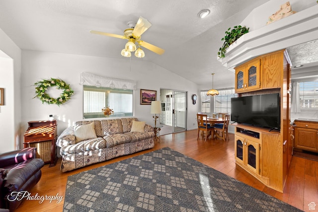 living room featuring lofted ceiling, ceiling fan, dark hardwood / wood-style floors, and a healthy amount of sunlight