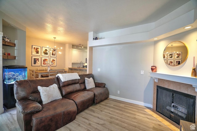 5338 S Beacon Hill Cir W Unit 181, Salt Lake City, UT 84123 - living room featuring light hardwood / wood-style flooring, sink, a fireplace, and a chandelier