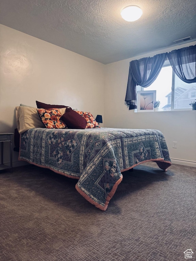 carpeted bedroom featuring a textured ceiling