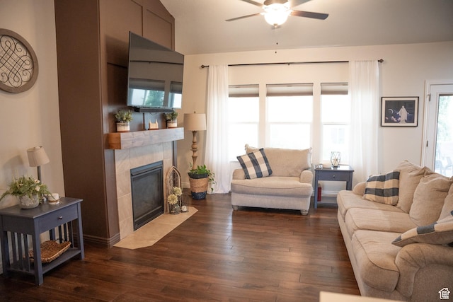 living room featuring ceiling fan, a fireplace, and dark hardwood / wood-style flooring