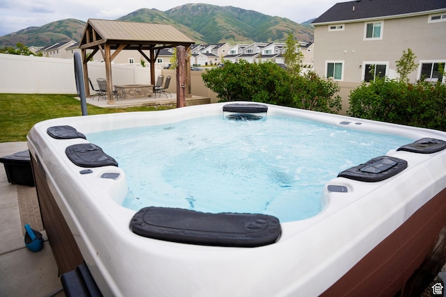 view of pool featuring a gazebo, a hot tub, a mountain view, and a patio area