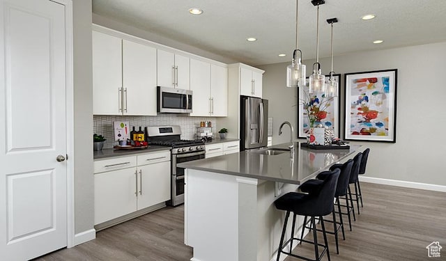 2146 W 3930 S Unit 20, Hurricane, UT 84737 - kitchen featuring pendant lighting, a breakfast bar, appliances with stainless steel finishes, white cabinetry, and an island with sink