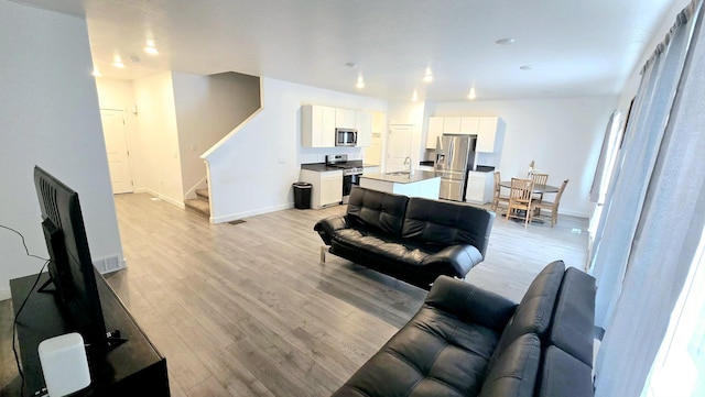 living room with sink and light wood-type flooring