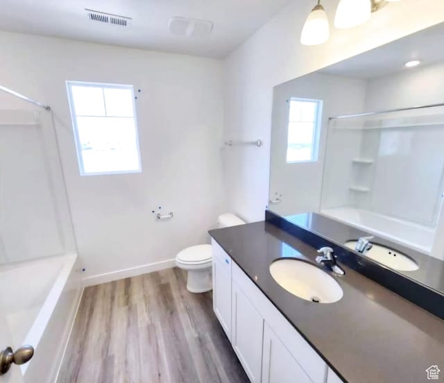 full bathroom featuring vanity, shower / bathing tub combination, hardwood / wood-style flooring, and toilet