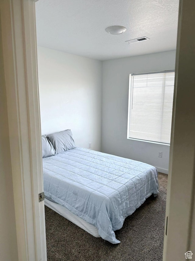 bedroom with carpet floors and a textured ceiling