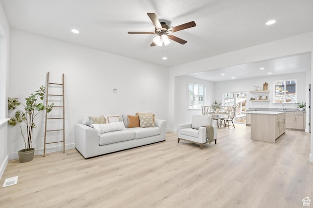 living area with recessed lighting, light wood-style floors, visible vents, and a ceiling fan