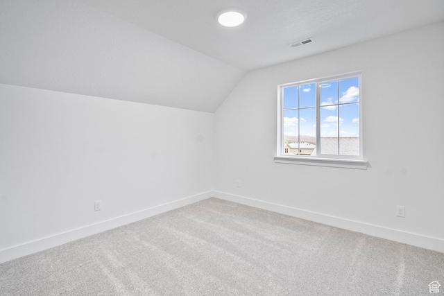 additional living space with visible vents, baseboards, carpet floors, and lofted ceiling