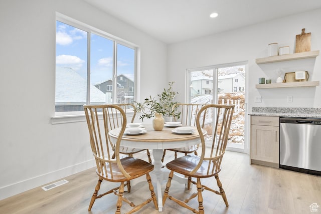dining area featuring visible vents, baseboards, light wood-type flooring, and plenty of natural light