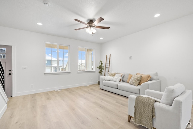living area featuring light wood-style floors, ceiling fan, and recessed lighting