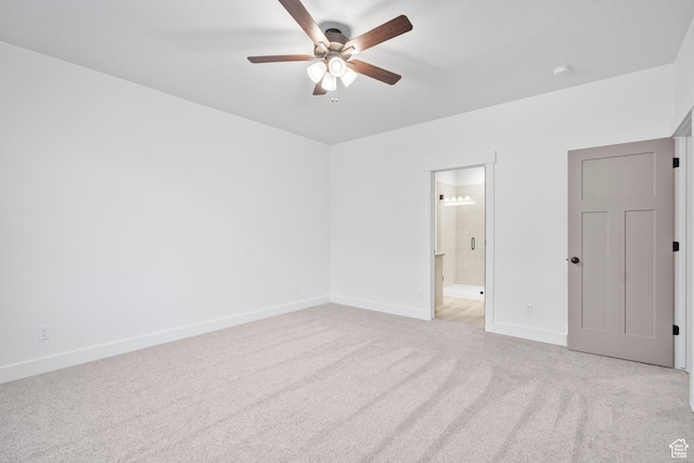 unfurnished bedroom with light carpet, ceiling fan, baseboards, and ensuite bath