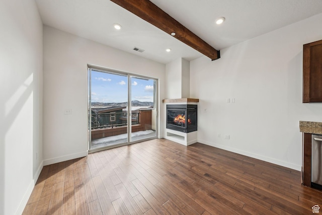 6169 Park Ln Unit 37, Park City, UT 84098 - unfurnished living room featuring beamed ceiling, a multi sided fireplace, and dark hardwood / wood-style flooring