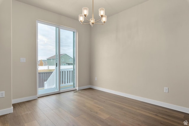 622 W Junegrass Ln, Stansbury Park, UT 84074 - unfurnished room featuring hardwood / wood-style floors and a chandelier