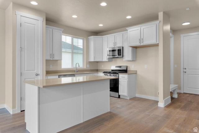 622 W Junegrass Ln, Stansbury Park, UT 84074 - kitchen featuring stainless steel appliances, white cabinetry, a kitchen island, and sink