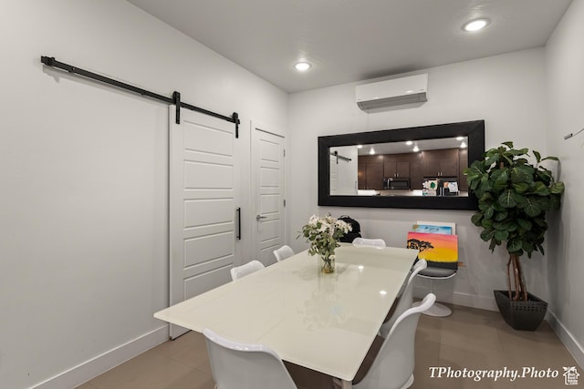 dining room with a barn door, light tile patterned flooring, and an AC wall unit
