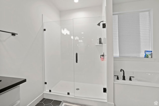 bathroom featuring tile patterned flooring, shower with separate bathtub, and vanity