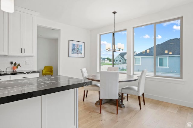 dining space with a chandelier and light hardwood / wood-style flooring