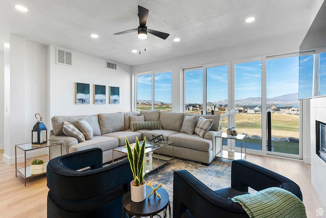 68 E Watson Dr S, Saratoga Springs, UT 84045 - living room featuring ceiling fan, a mountain view, a textured ceiling, and light wood-type flooring