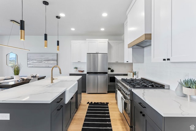 68 E Watson Dr S, Saratoga Springs, UT 84045 - kitchen featuring premium range hood, white cabinetry, hanging light fixtures, appliances with stainless steel finishes, and an island with sink