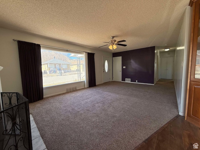 unfurnished living room with dark colored carpet, a textured ceiling, and ceiling fan