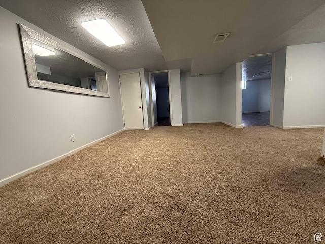 basement featuring carpet flooring and a textured ceiling