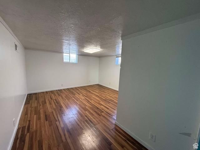 unfurnished room featuring dark hardwood / wood-style floors and a textured ceiling