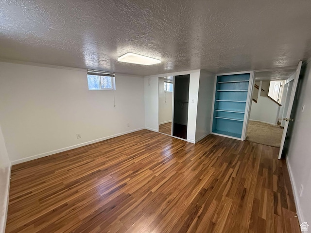 basement featuring a closet, dark hardwood / wood-style flooring, and a textured ceiling