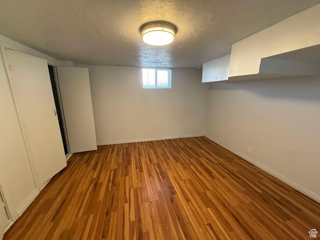 basement with wood-type flooring and a textured ceiling
