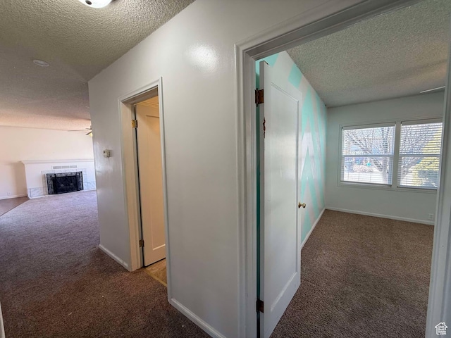 corridor with carpet and a textured ceiling