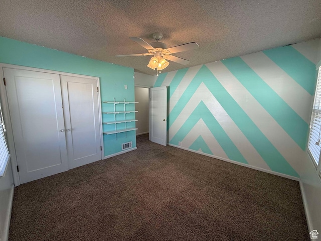 unfurnished bedroom with ceiling fan, carpet floors, a textured ceiling, and a closet