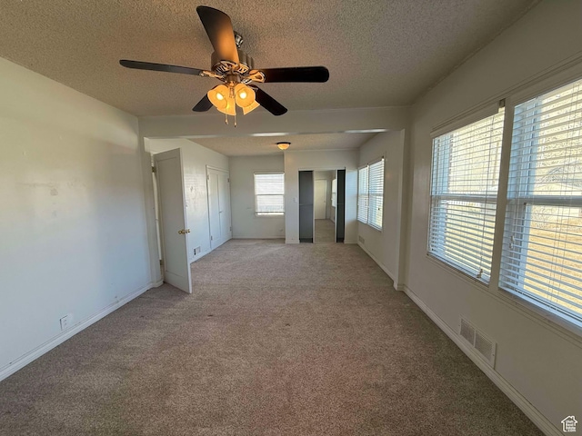 carpeted spare room with a textured ceiling