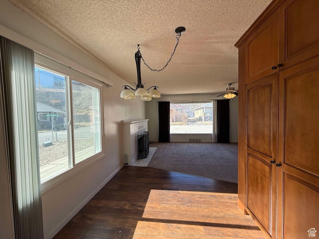 hallway featuring a notable chandelier, dark hardwood / wood-style floors, and a textured ceiling