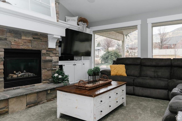 living room with lofted ceiling, a fireplace, and carpet flooring