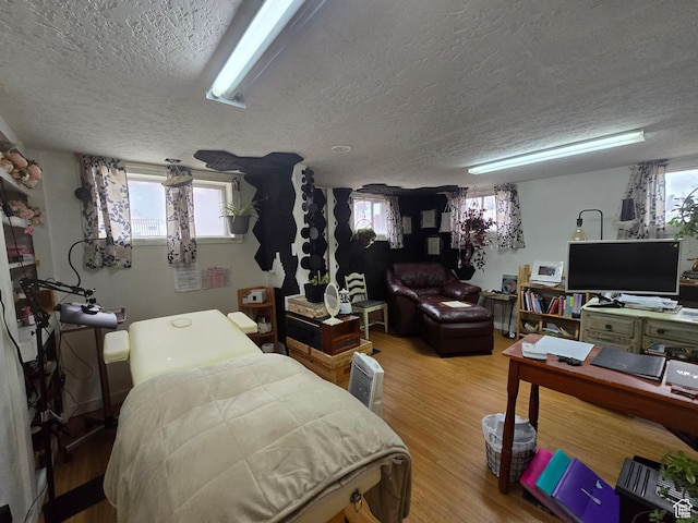 bedroom featuring wood finished floors and a textured ceiling